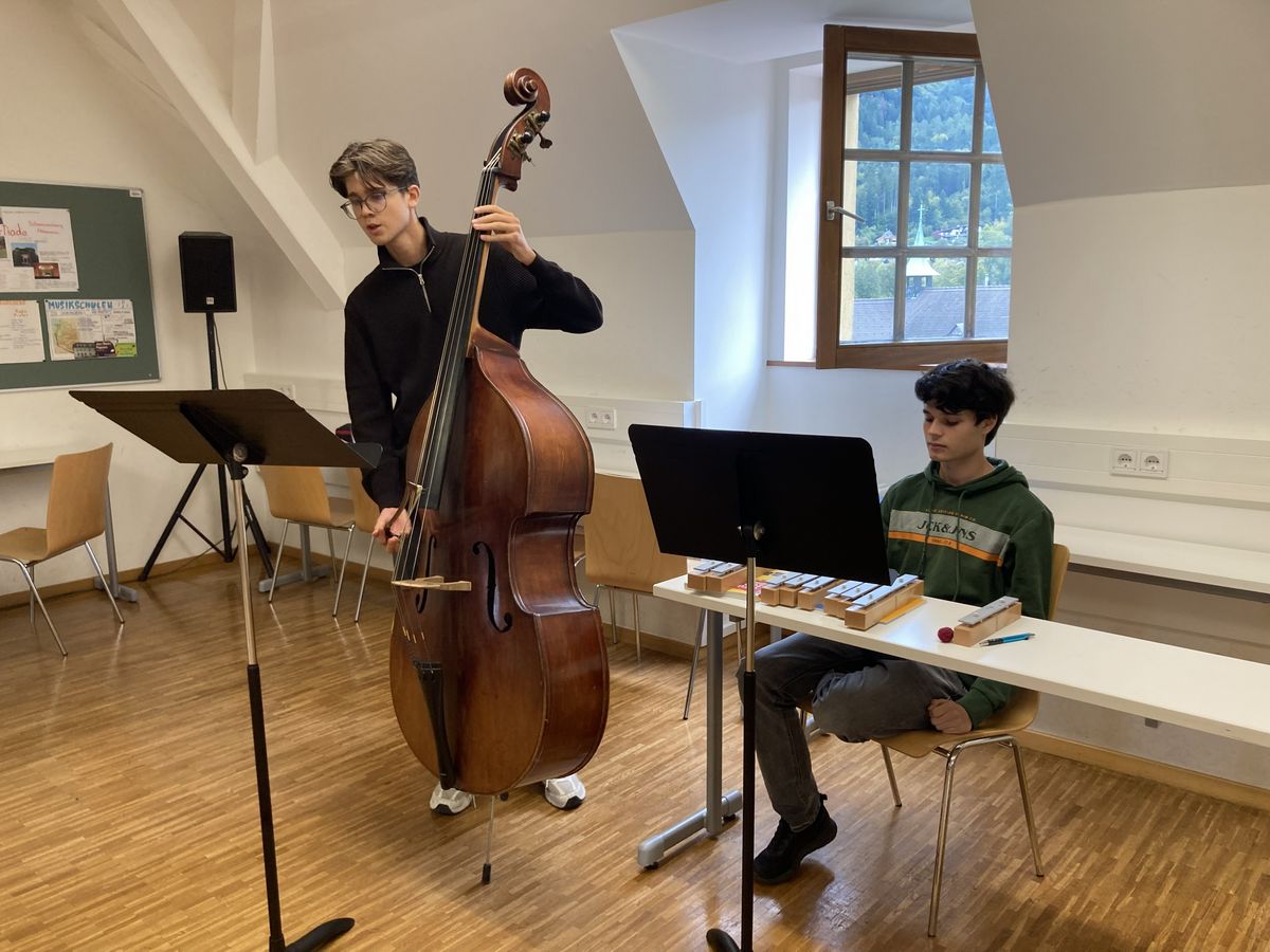 Junge Musiker üben im Proberaum mit Kontrabass und Glockenspiel